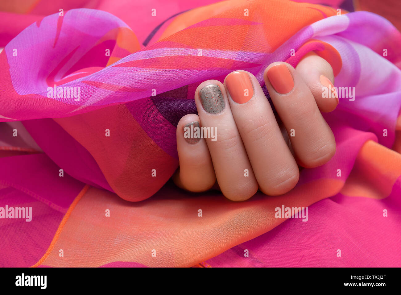 Femmina con mano arancione e grigio nail design Foto Stock