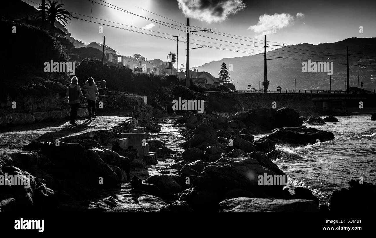 Gli amici passeggiando lungo il Sud Africa è falso costa della baia vicino alla penisola del capo villaggio di Glencairn nei pressi di Città del Capo Foto Stock