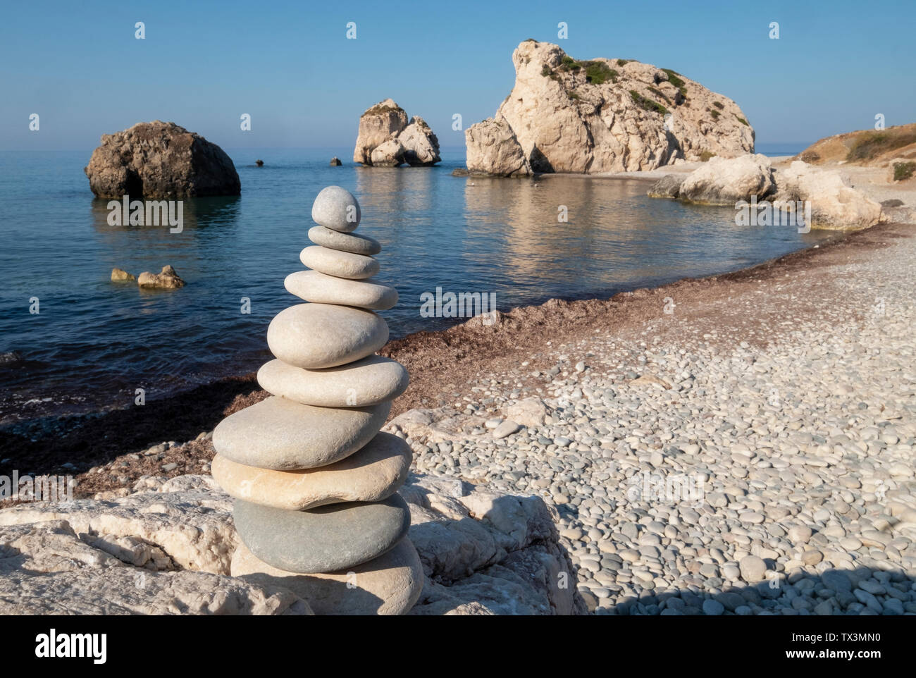 Una pila di pietra nella parte anteriore della roccia di Afrodite (Petra tou Romiou), regione di Paphos, Repubblica di Cipro. Foto Stock