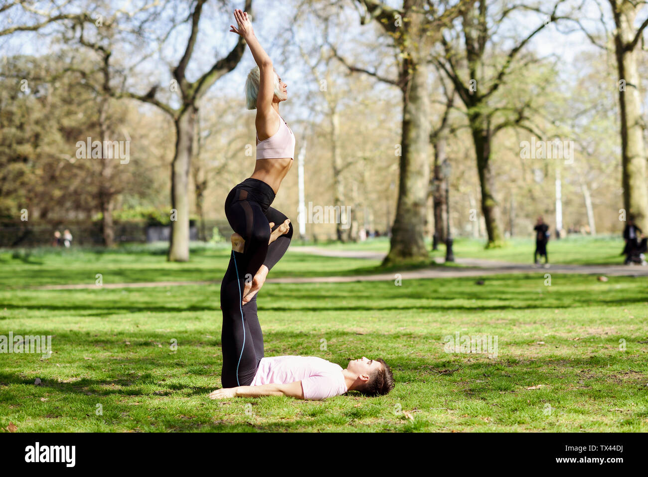 Coppia giovane fare yoga acrobazie in un parco urbano Foto Stock