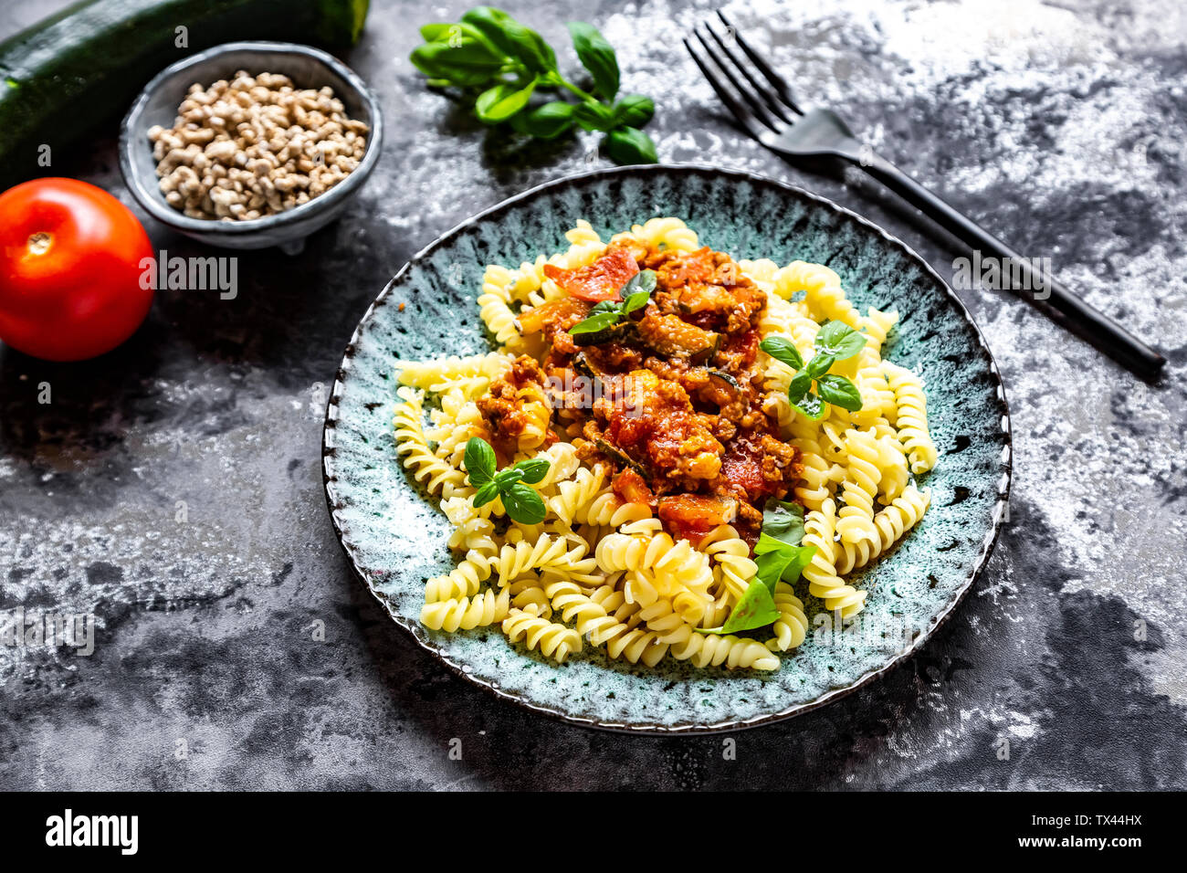 Spirelli con bolognese vegetariana, girasole tritare, zucchine, pomodori, parmigiano e basilico Foto Stock
