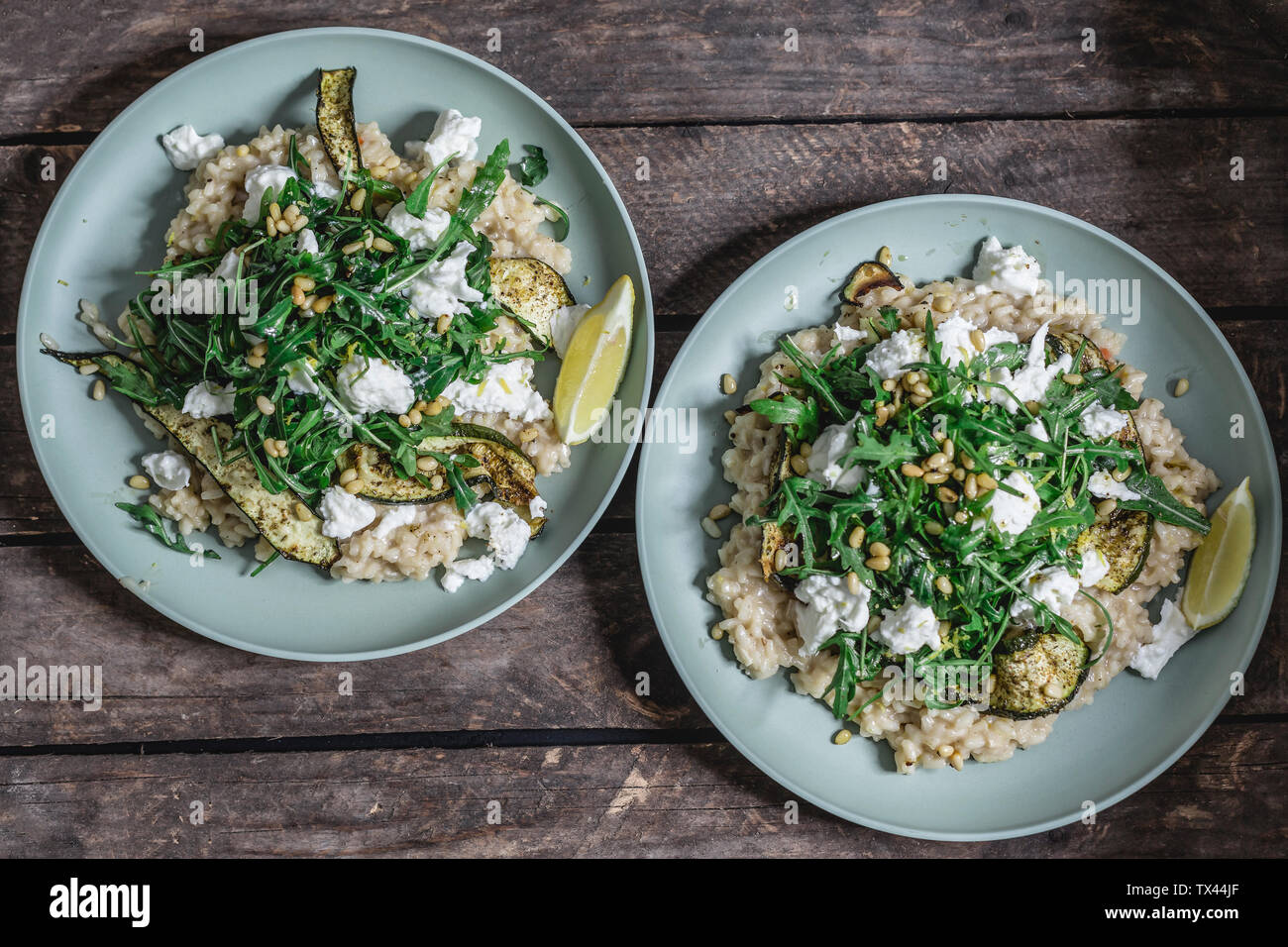 Due piastre di limone il risotto con la mozzarella di bufala, rucola, cotta la zucchina e pinoli Foto Stock