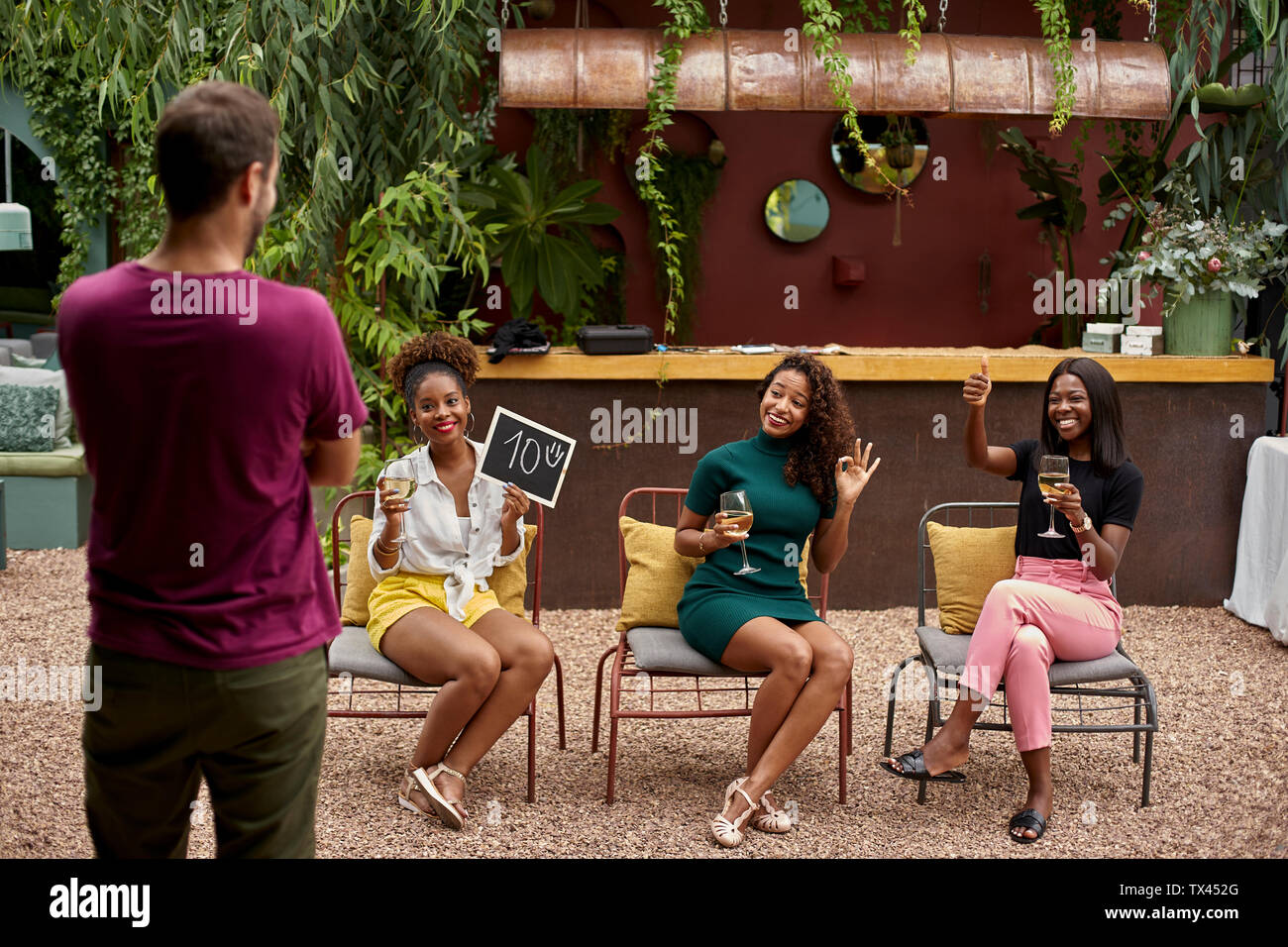 Tre giovani donne rating di un uomo, avente fun Foto Stock