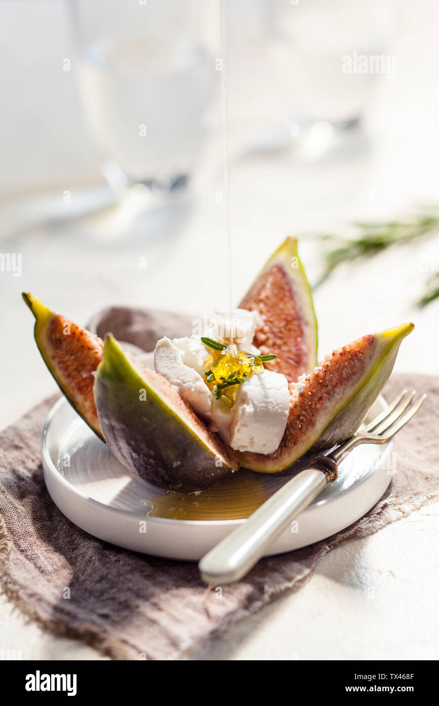Fichi e formaggio di capra, rosmarino, versando con miele Foto Stock