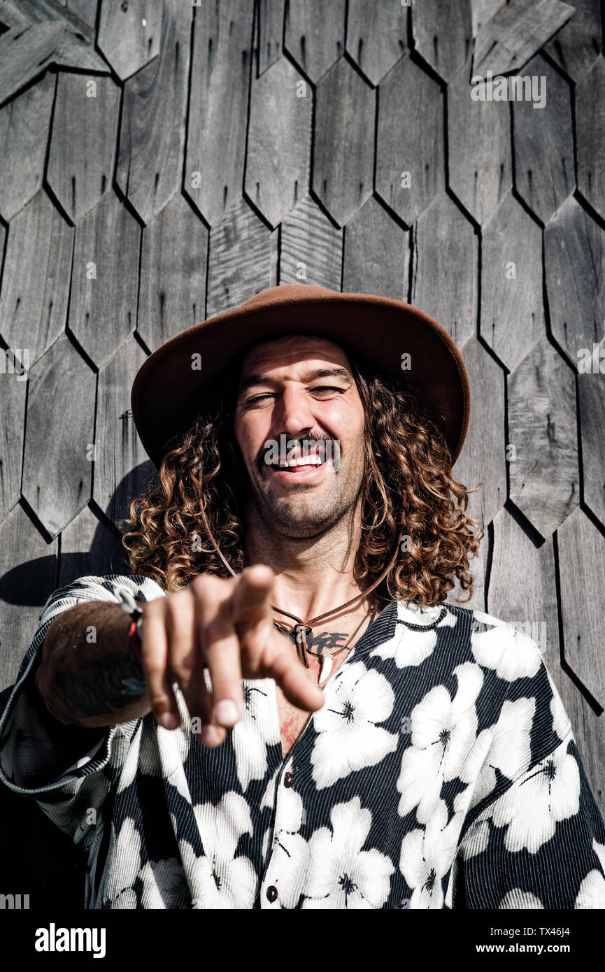 Ritratto di uomo che indossa un cappello e camicia hawaiana puntando sul visore Foto Stock