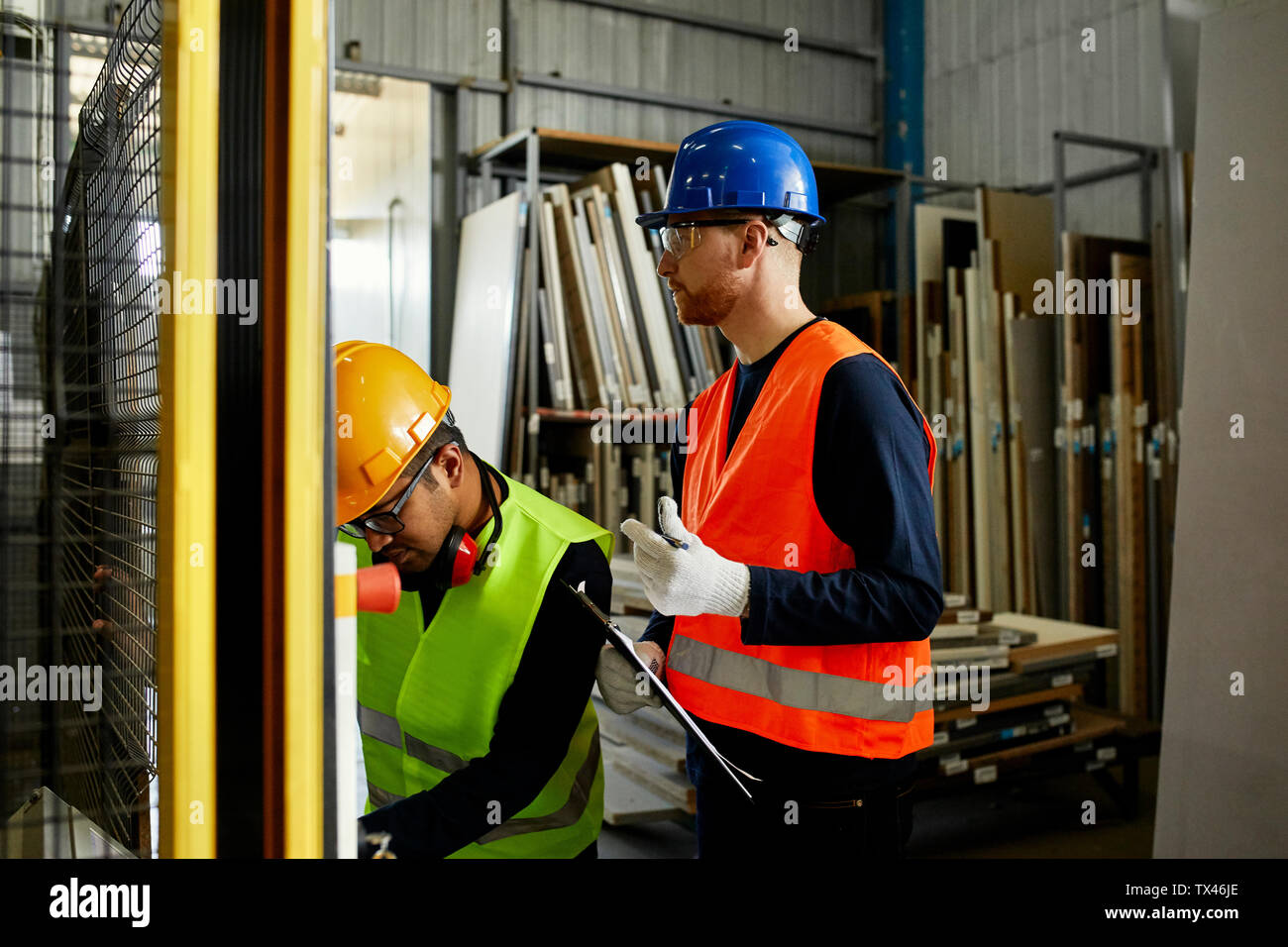 Due uomini macchina operatrice in fabbrica industriale Foto Stock