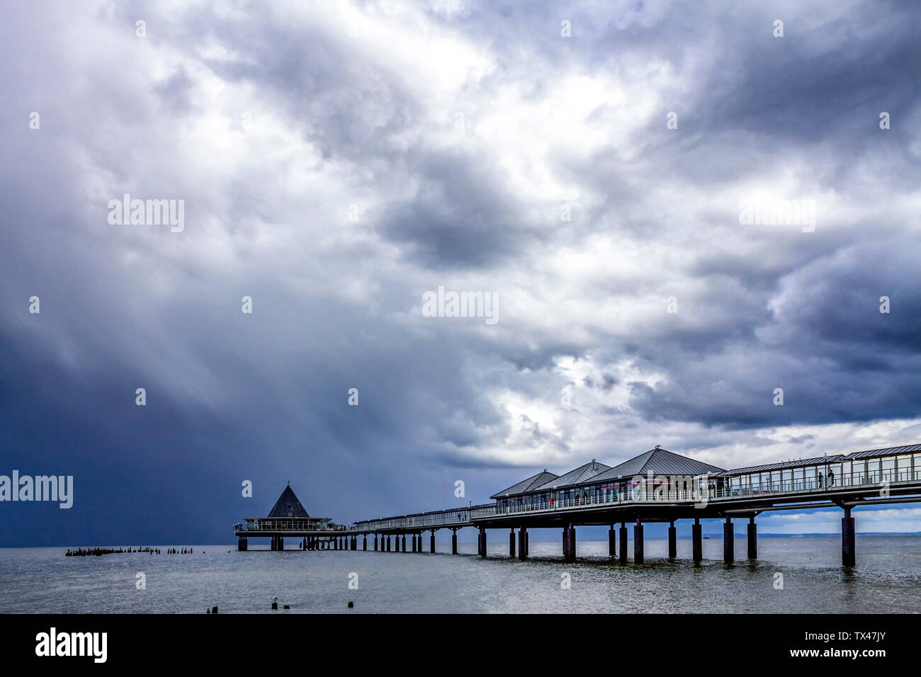 Germania, Usedom, Heringsdorf, pier sotto il cielo nuvoloso Foto Stock