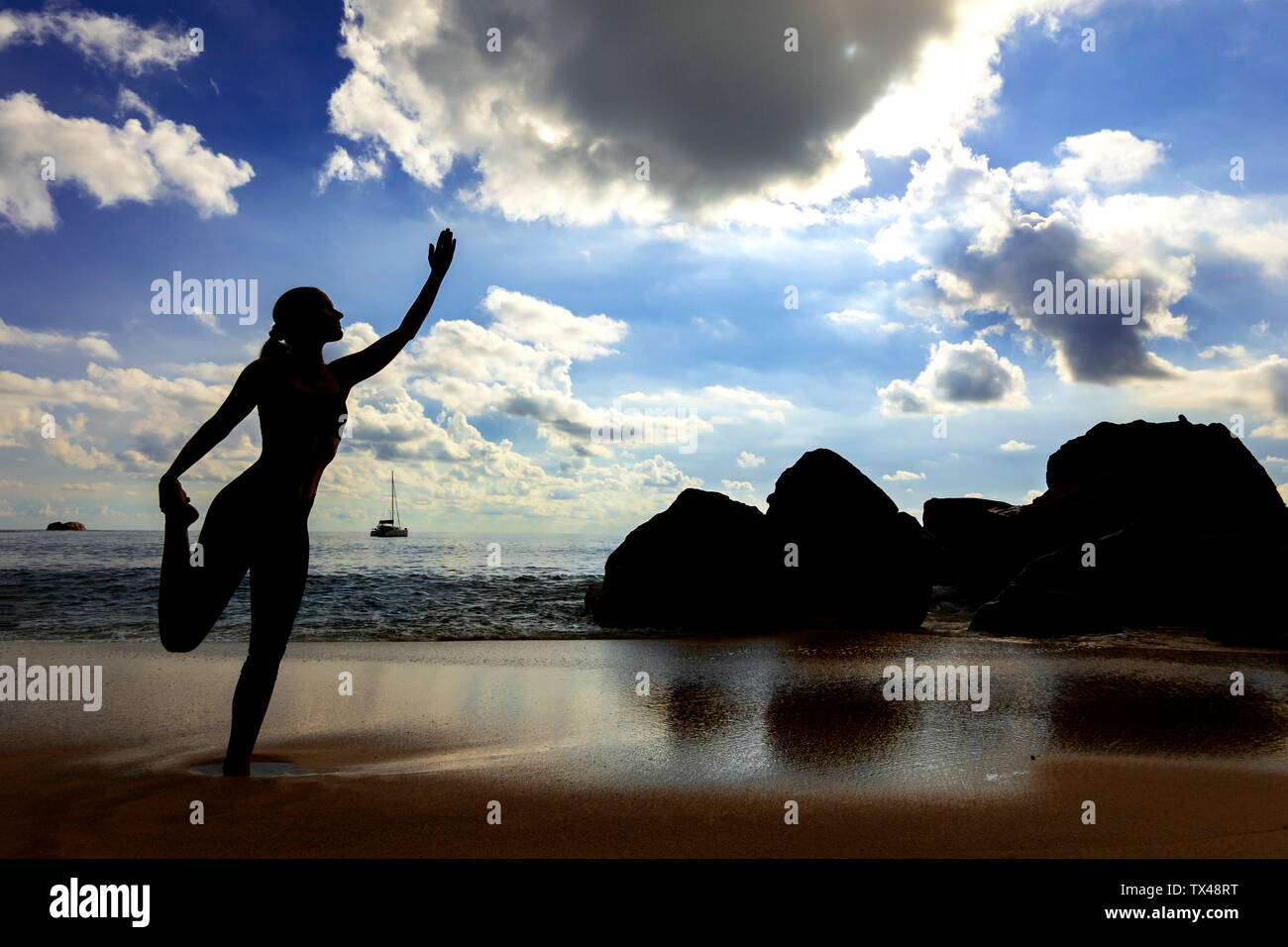 Seychelles, Mahe, Takamaka Beach, silhouette di donna fare yoga sulla spiaggia Foto Stock