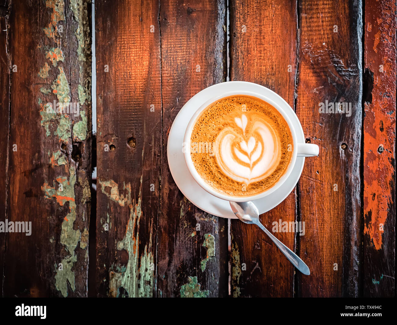 Una tazza di cappuccino in una tabella in un cafe'. Bella pianta disegno  foglia sul caffè latte con la schiuma. Vista da sopra. Lay piatto. Un  delizioso caffè per Foto stock -