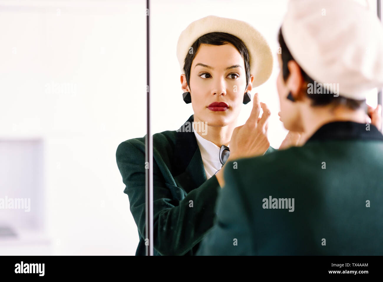 Moda giovane donna controllando il suo guardare nello specchio Foto Stock