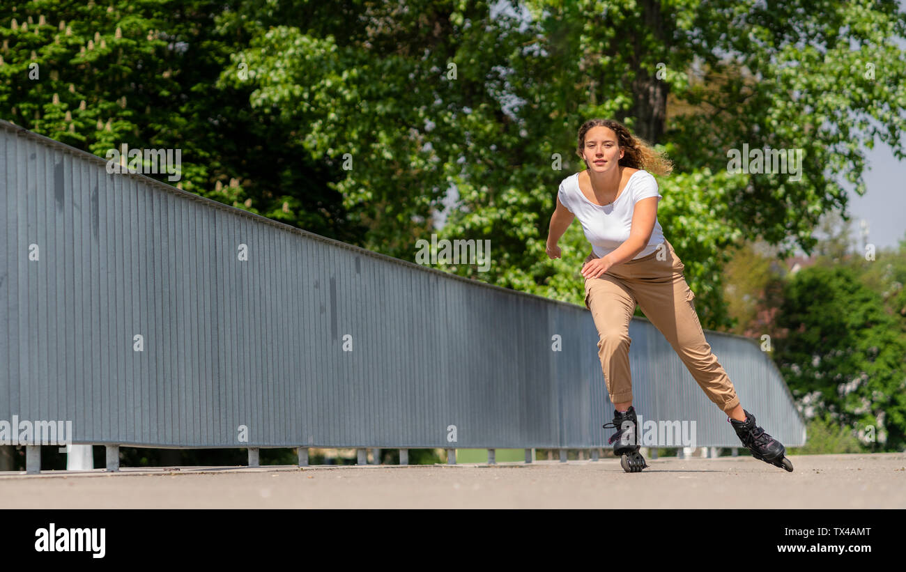 Giovane donna inline skating nella città, Waiblingen, Germania Foto Stock