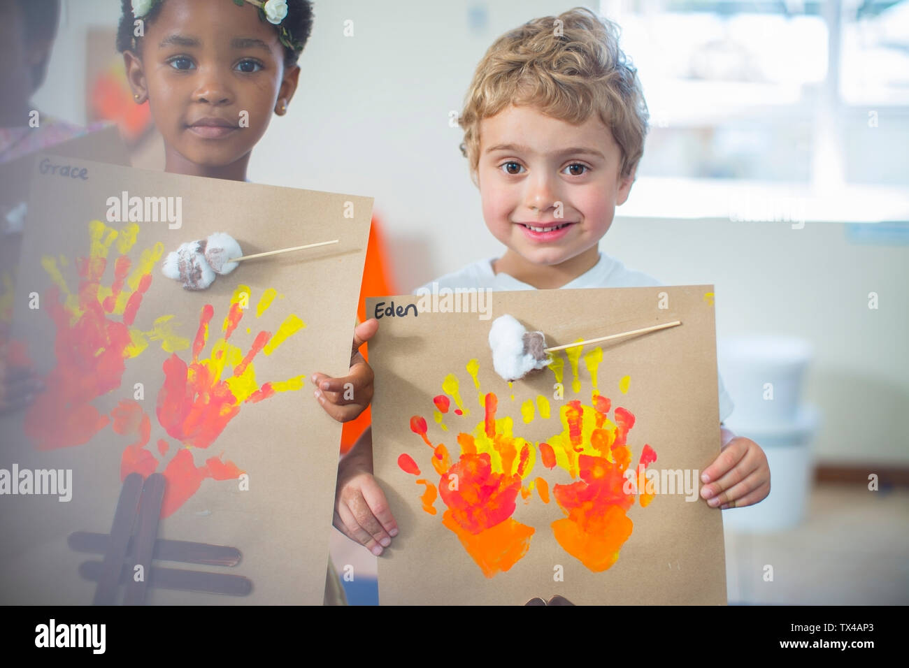 Ritratto di bambini sorridenti presentare le immagini di un incendio in una scuola materna Foto Stock