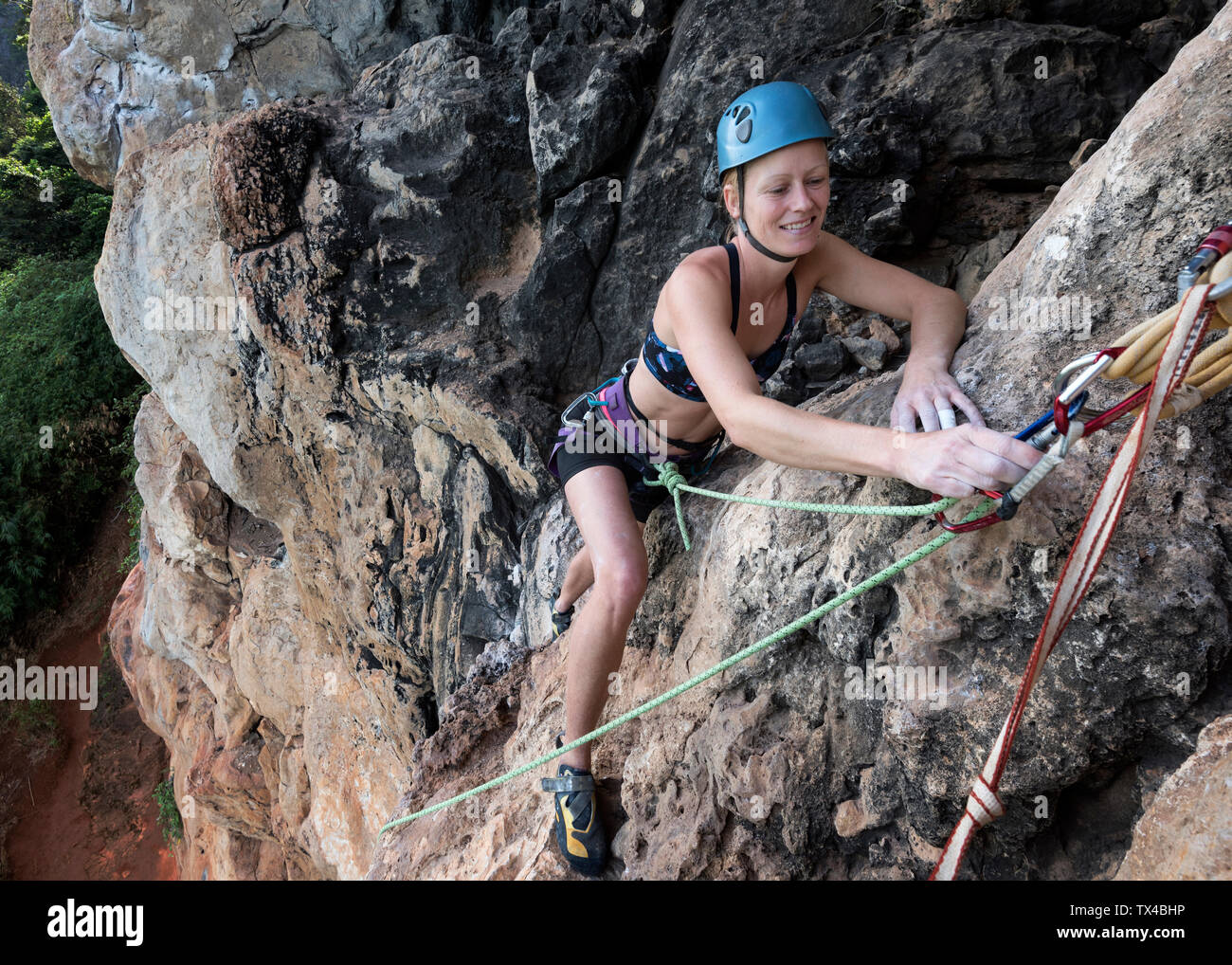 Thailandia, Krabi, Thaiwand wall, donna sorridente arrampicate in roccia della parete Foto Stock