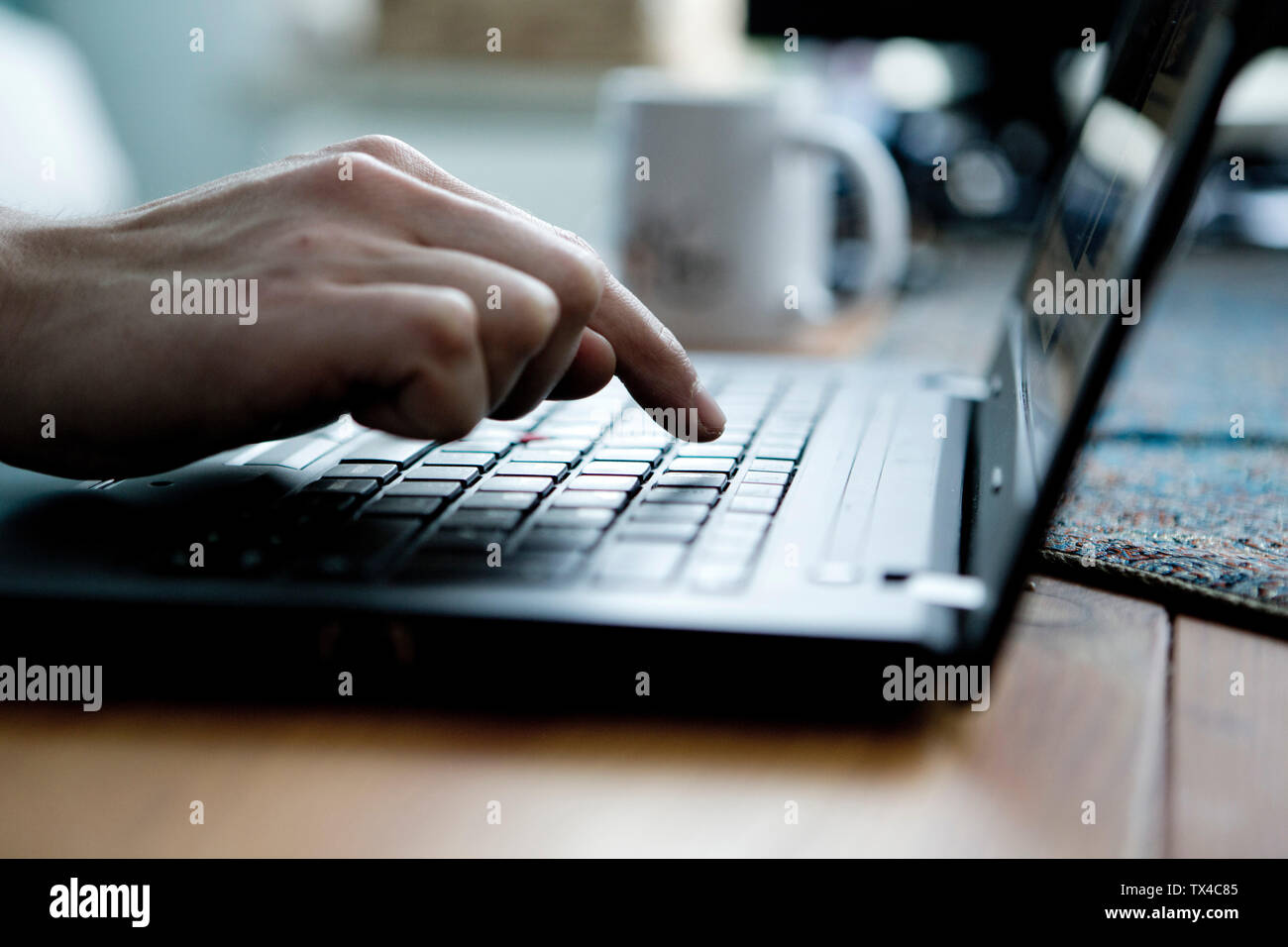 La digitazione a mano con un dito di una mano su un computer portatile Foto Stock