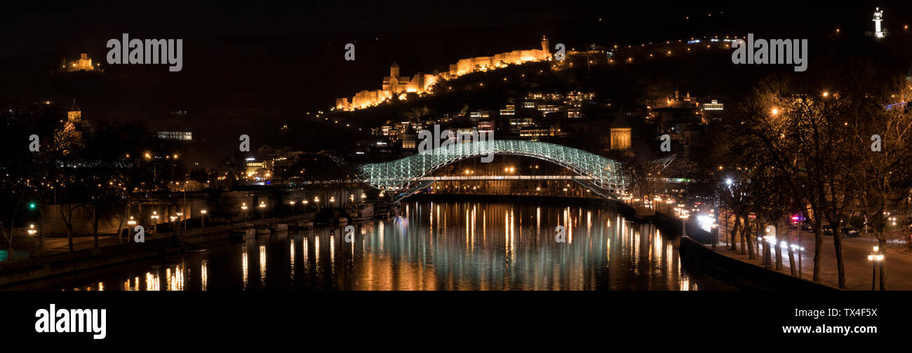 La Georgia, Tbilisi, ponte di pace e fortezza di Narikala di notte Foto Stock
