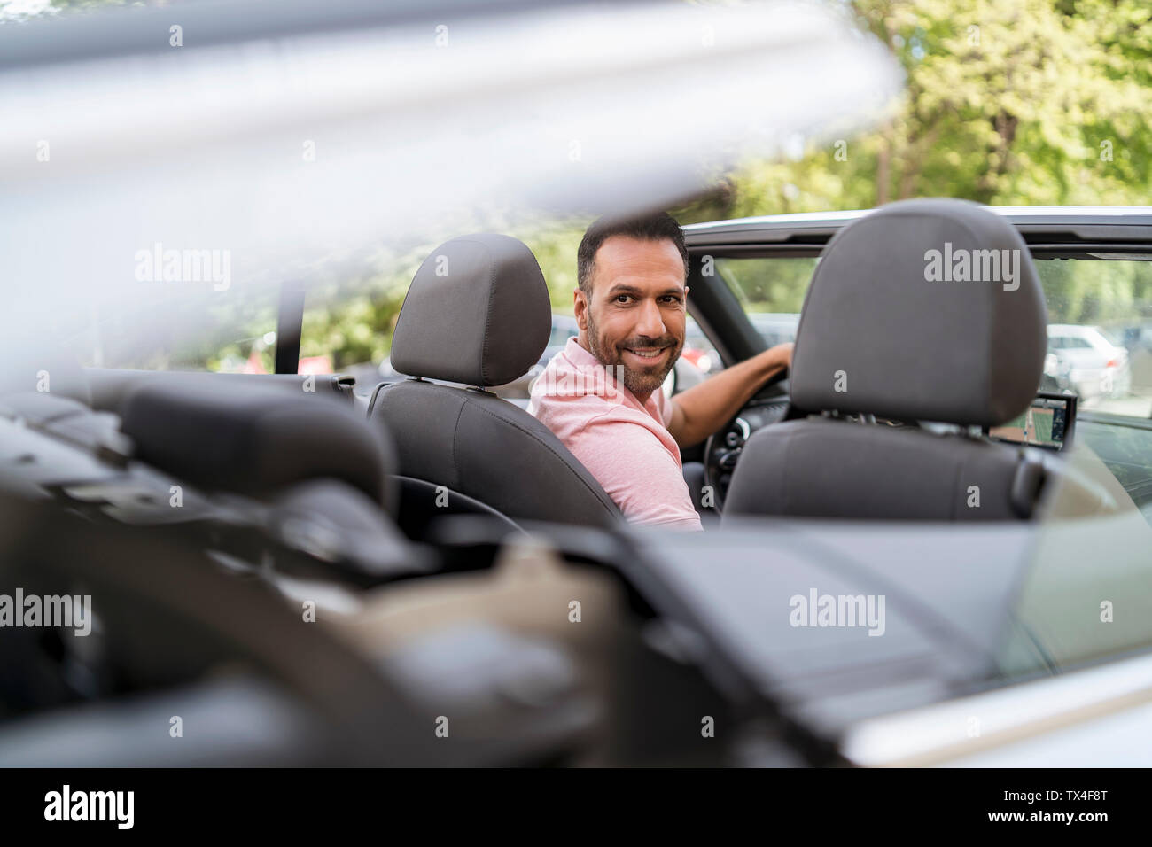 Uomo seduto in auto con la chiusura della capote Foto Stock