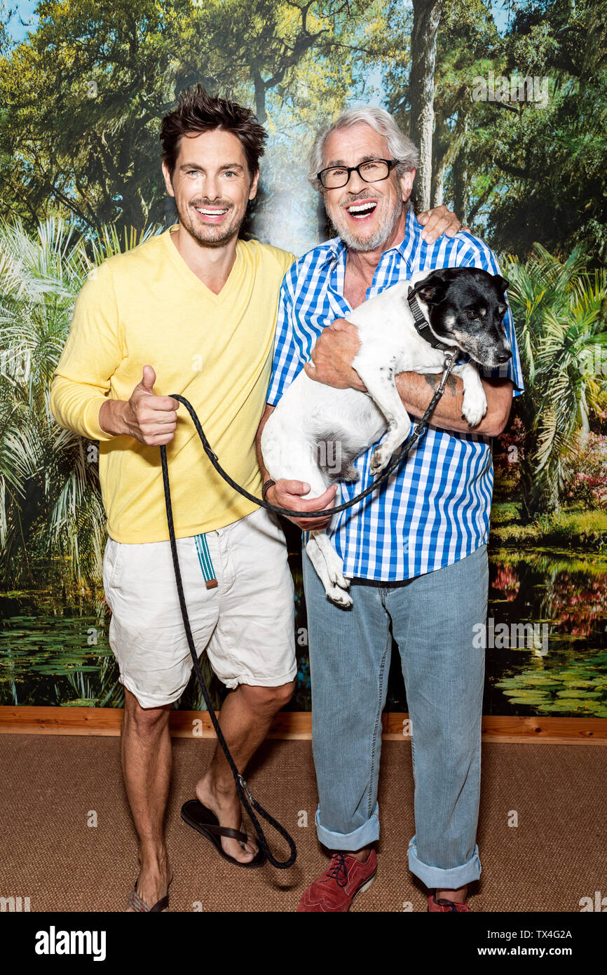 Padre e figlio in piedi di fronte a uno sfondo di foto Foto Stock