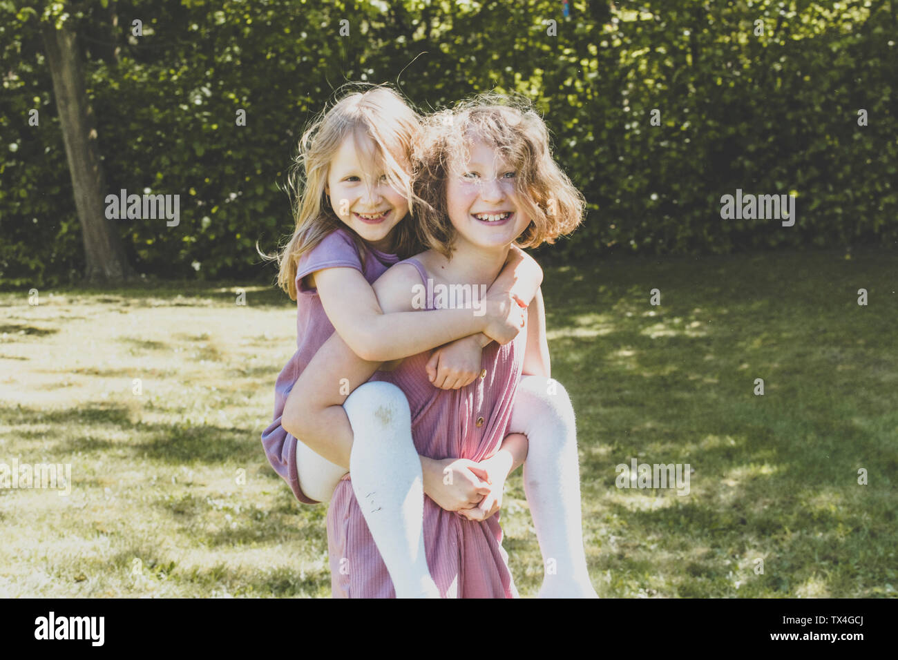 Un big sister portando la sua piccola sorella, Girl power Foto Stock