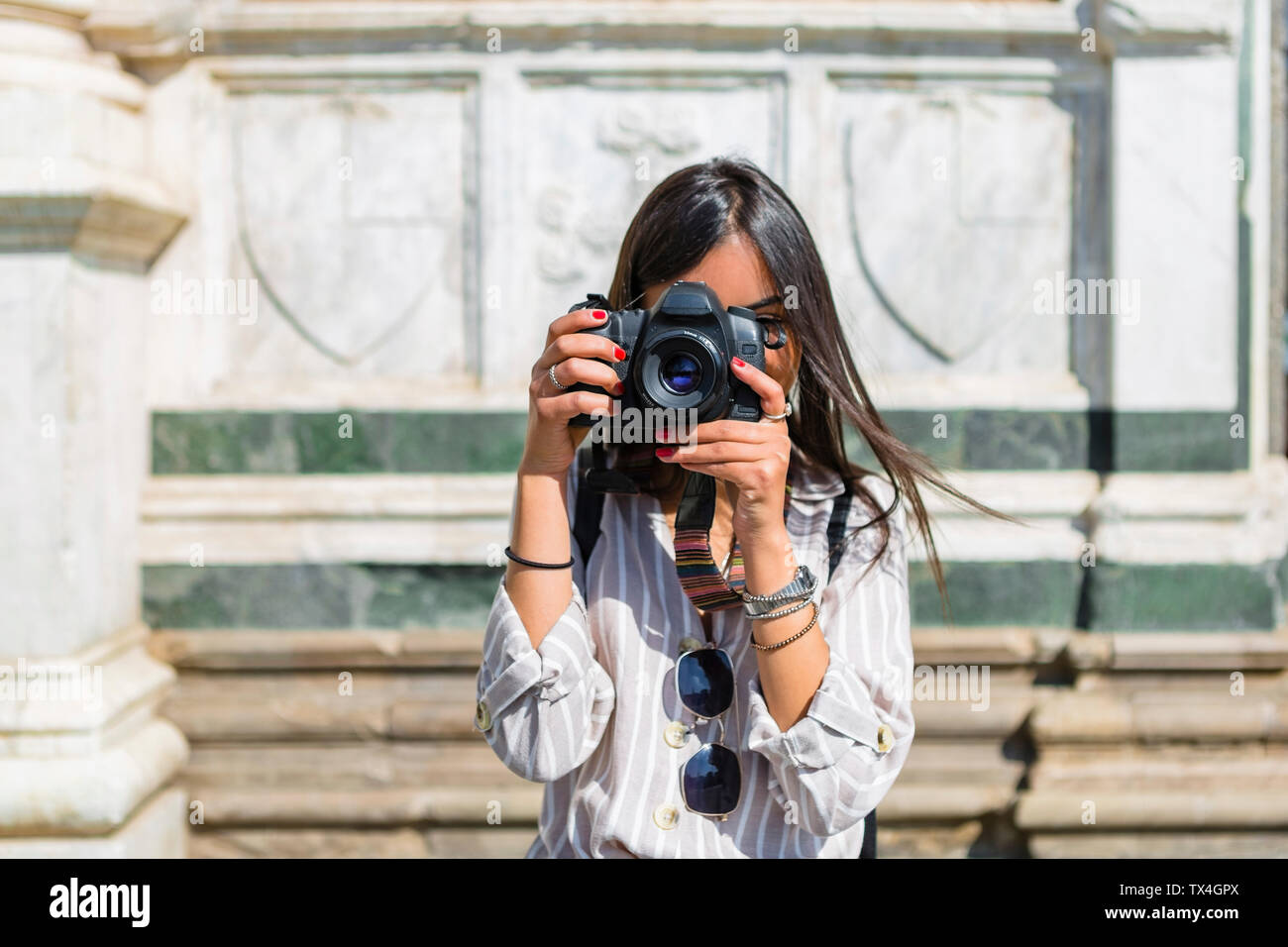 L'Italia, Firenze, giovane turista tenendo fotografia con la fotocamera Foto Stock