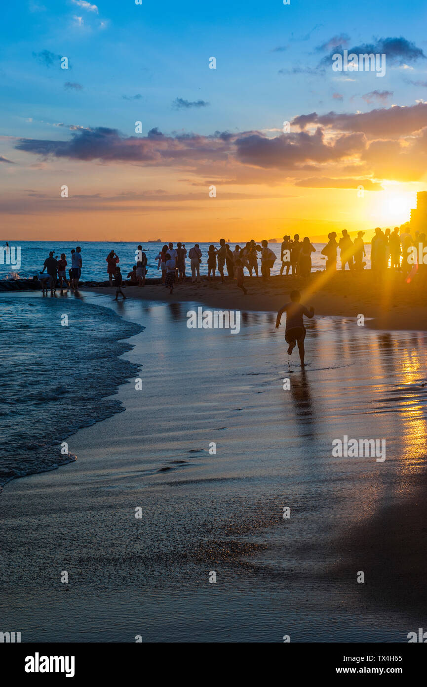 Hawaii, Oahu, Waikiki Beach, turisti e guardare il tramonto Foto Stock