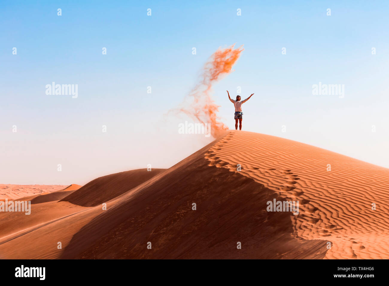 Il sultanato di Oman, Wahiba Sands, metà uomo adulto è il gioco con la sabbia nel deserto Foto Stock