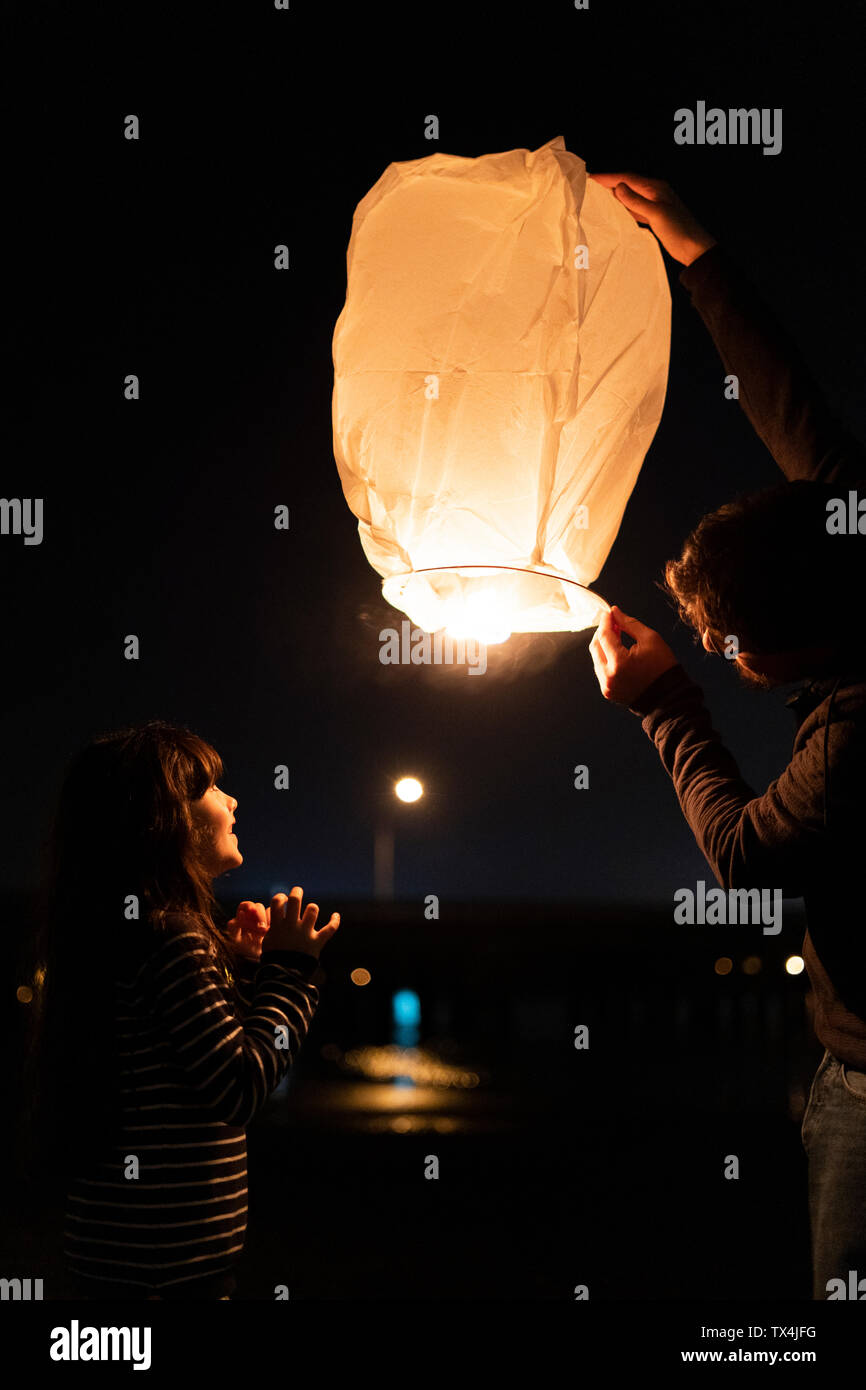 Padre e figlia preparare una lanterna di cielo di notte Foto Stock