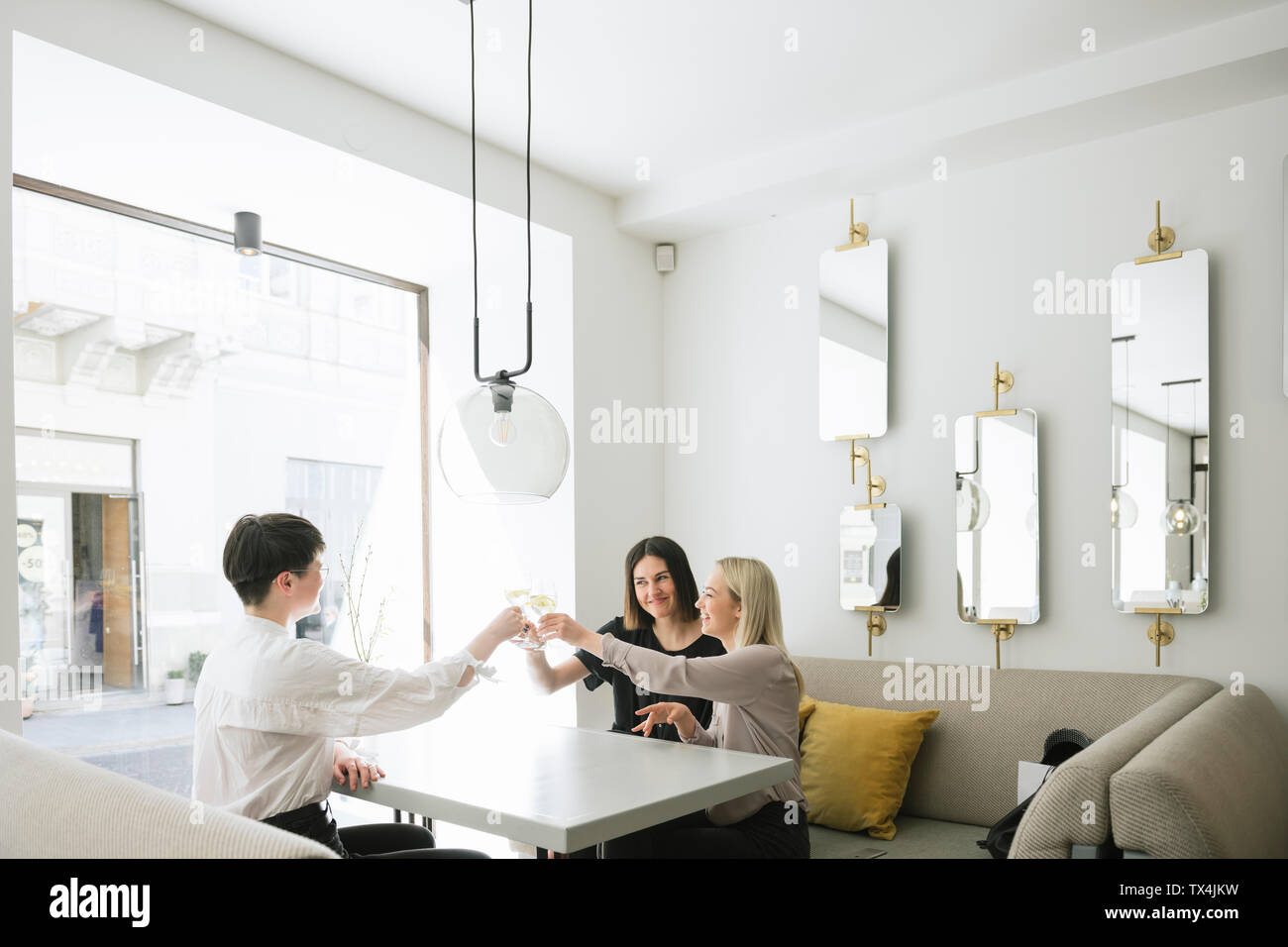 Happy amici tostare bicchieri di acqua in un ristorante Foto Stock