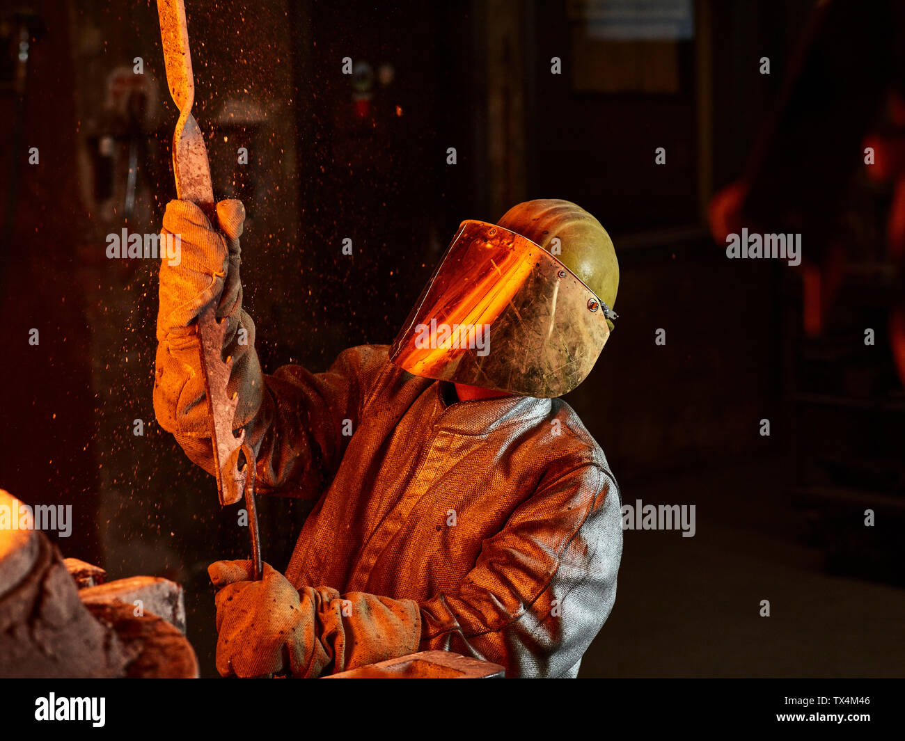 Industria, lavoratore in forno durante la fusione del rame, indossando un incendio tuta di prossimità Foto Stock