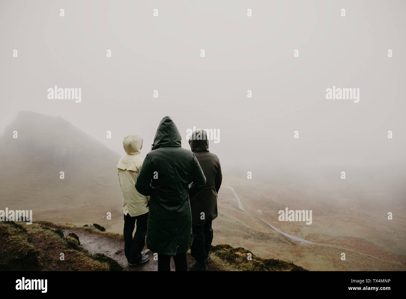 Regno Unito, Scozia, Isola di Skye, Quiraing Viewpoint, vista posteriore di tre donne nel paesaggio di nebbia Foto Stock