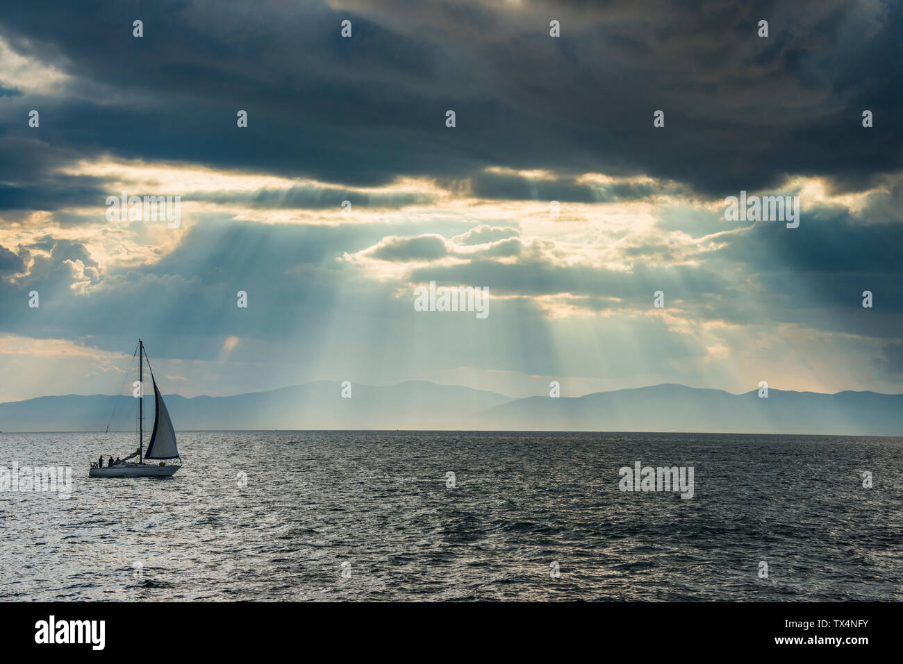 Barca a vela prima della rottura sole attraverso le nuvole sopra di Amur a Vladivostok, Russia Foto Stock