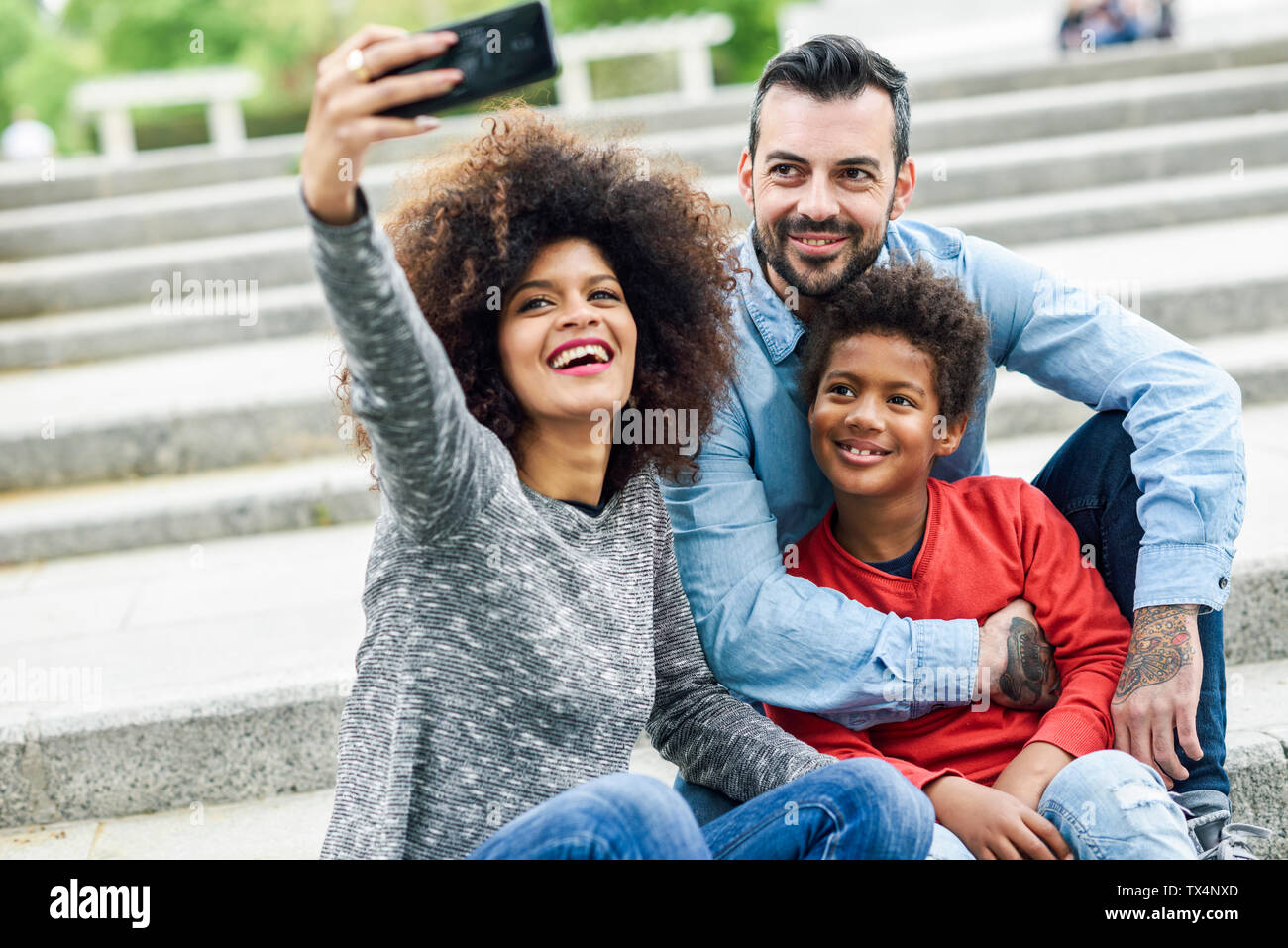 La famiglia felice tenendo selfies in un parco Foto Stock