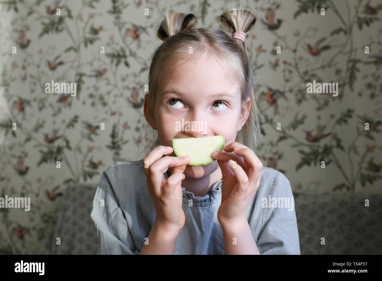 Ritratto di ragazza bionda con fette di zucchine Foto Stock