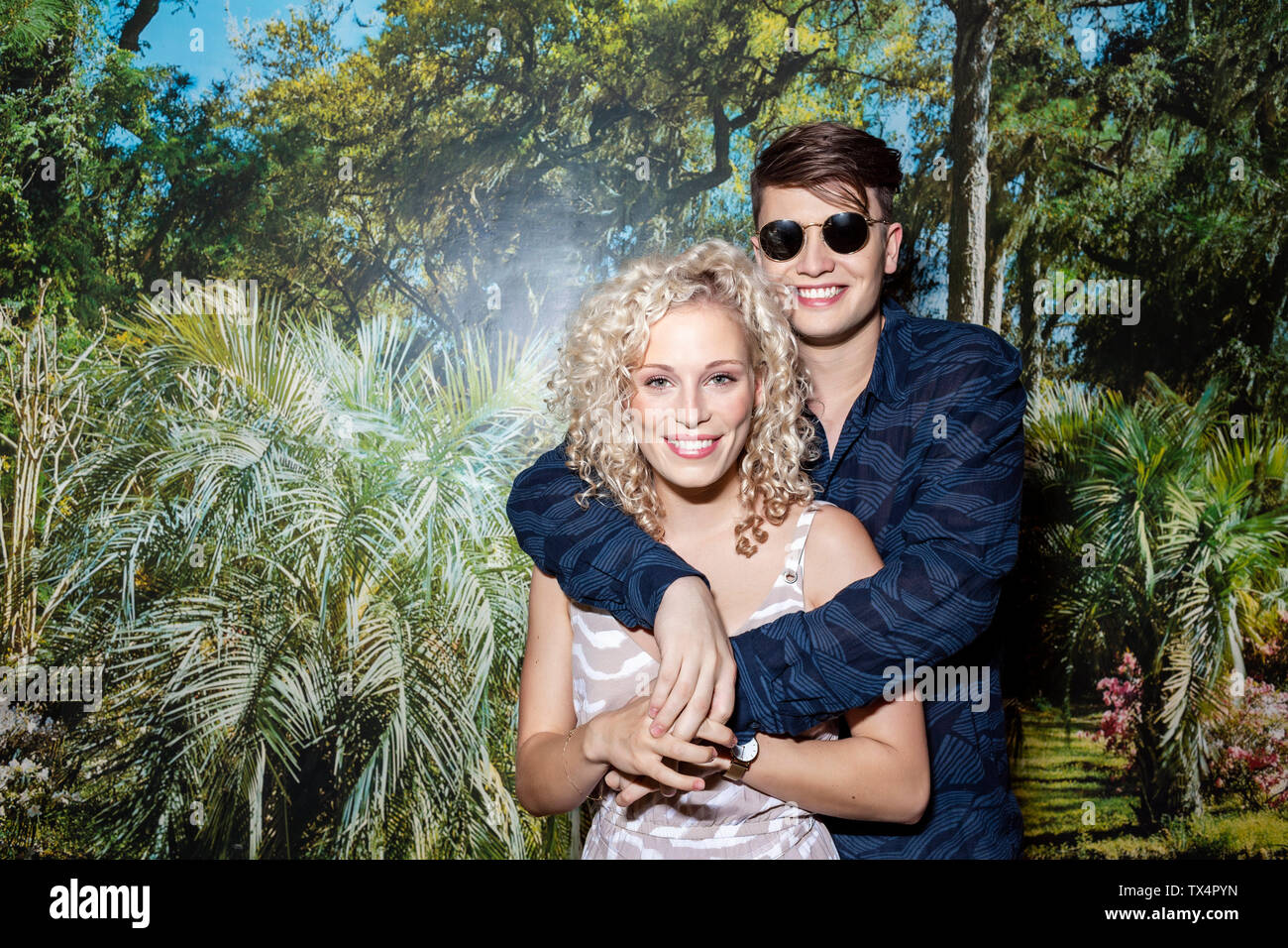Coppia giovane in piedi di fronte a uno sfondo fotografico, ritratto Foto Stock