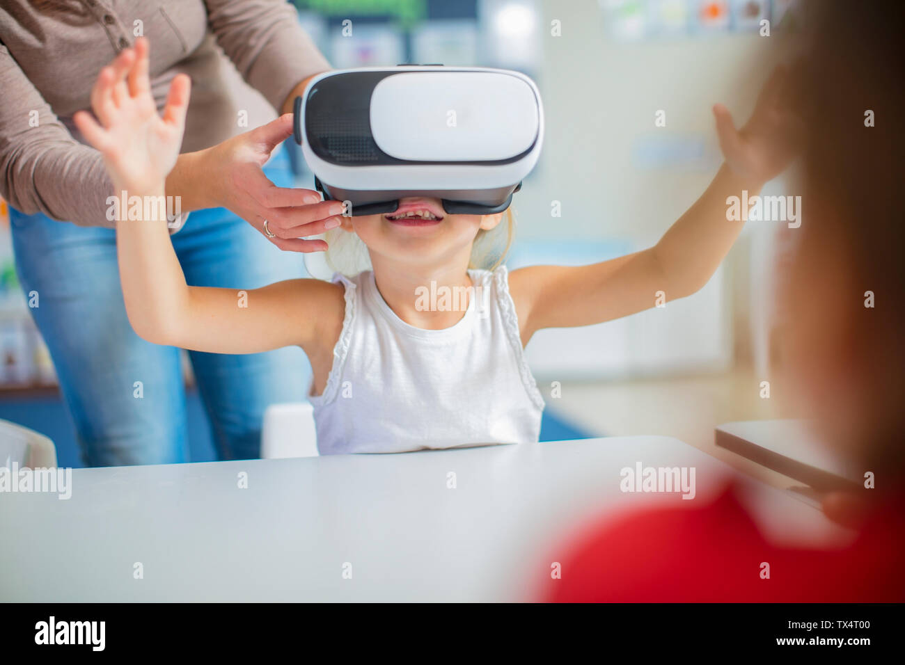 Pre-insegnante e la bambina in una scuola materna con occhiali VR Foto Stock