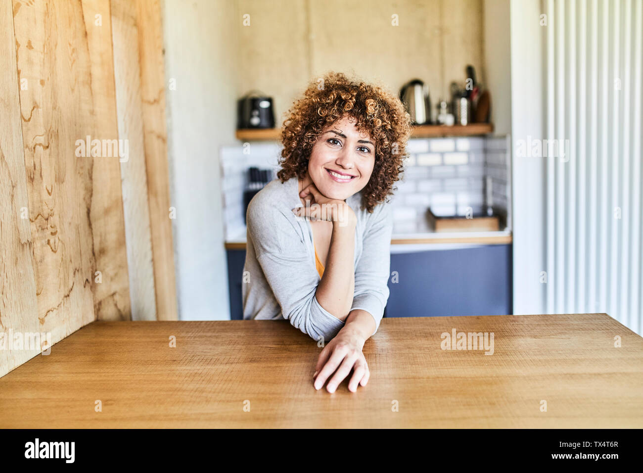 Ritratto di donna sorridente appoggiato sulla tavola di legno Foto Stock