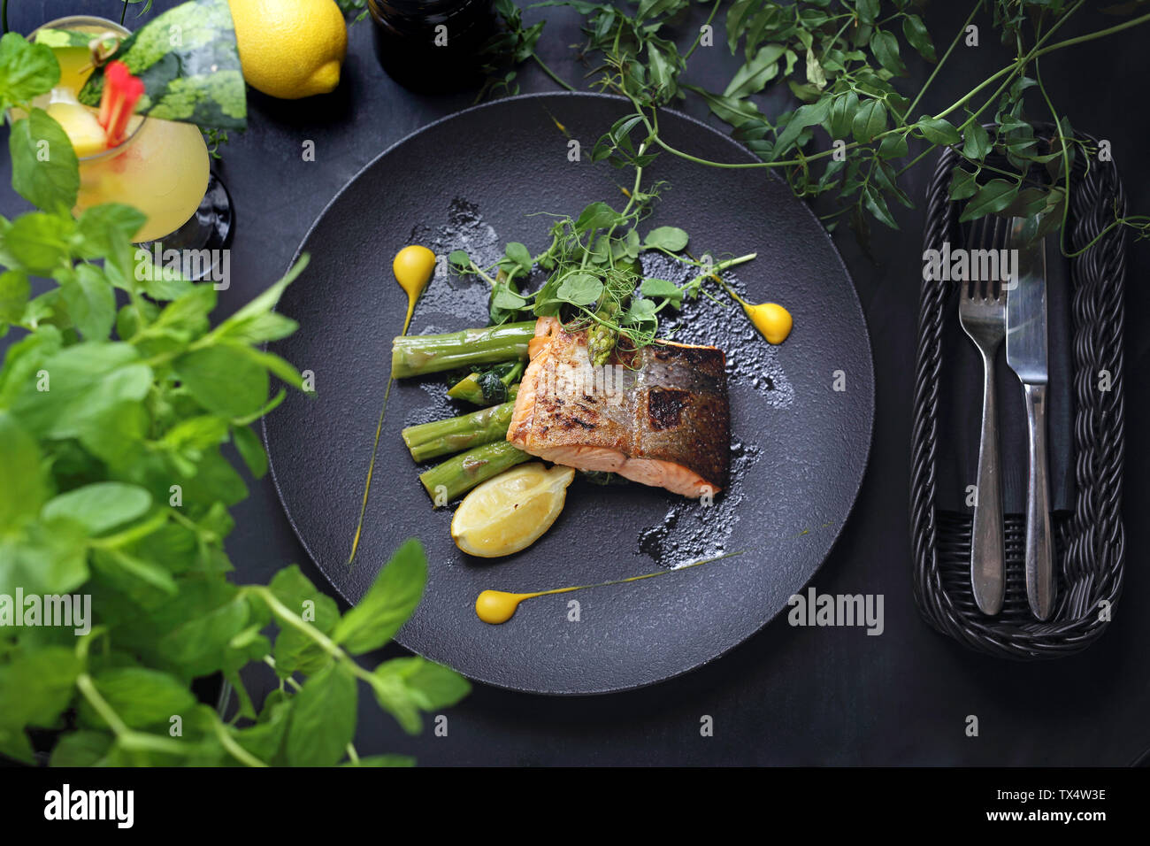 Di salmone al forno di filetto con salsa di limone servita su asparagi verdi. Un elegante piatto squisito. Foto Stock