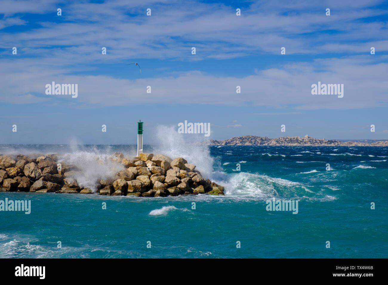 Francia, Marsiglia, Luogo Firenze Arthaud, La Madrague, onde forti ad un molo con il faro Foto Stock