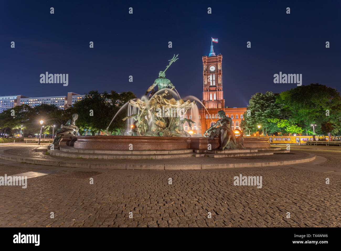 Germania, Berlino, vista di rosso illuminato City Hall e fontana di Nettuno a notte Foto Stock