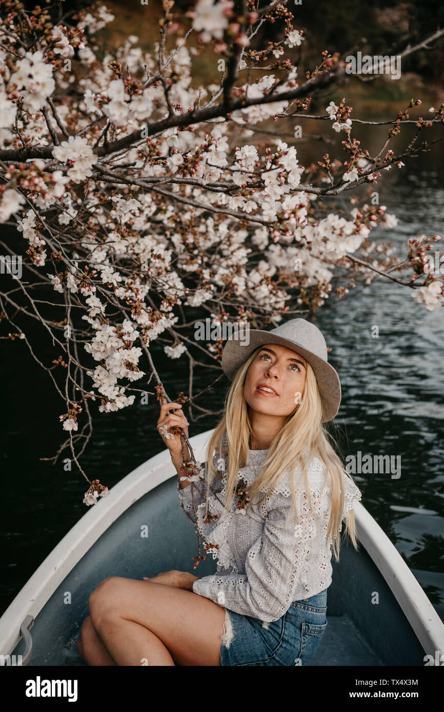 Giappone, Tokio, Parco Chidorigafuchi, donna in barca a remi ammirando il ciliegio blossom Foto Stock