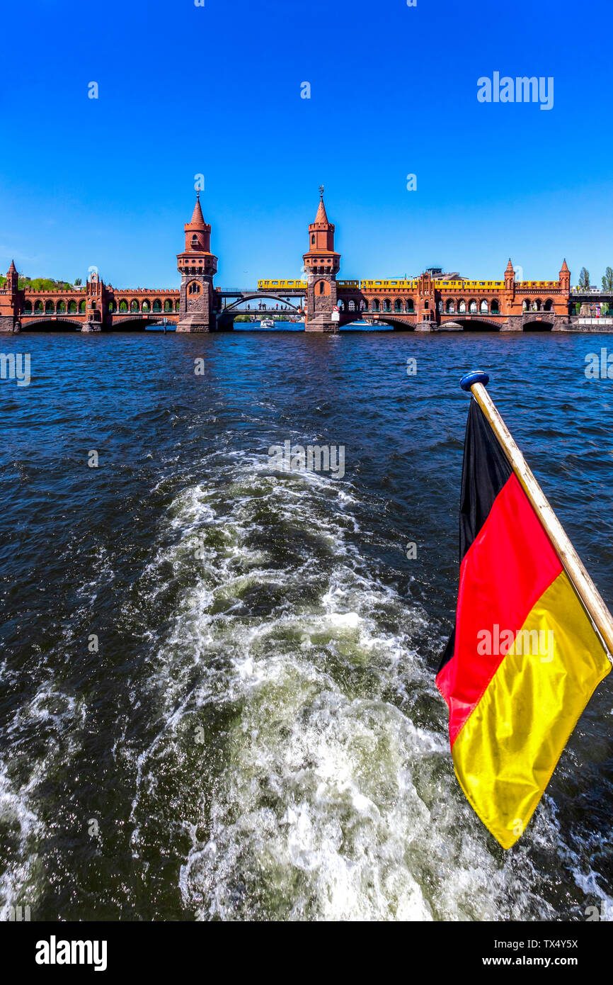 Germania, Berlino, Oberbaum Ponte e bandiera tedesca sulla barca per gite sul fiume Spree Foto Stock