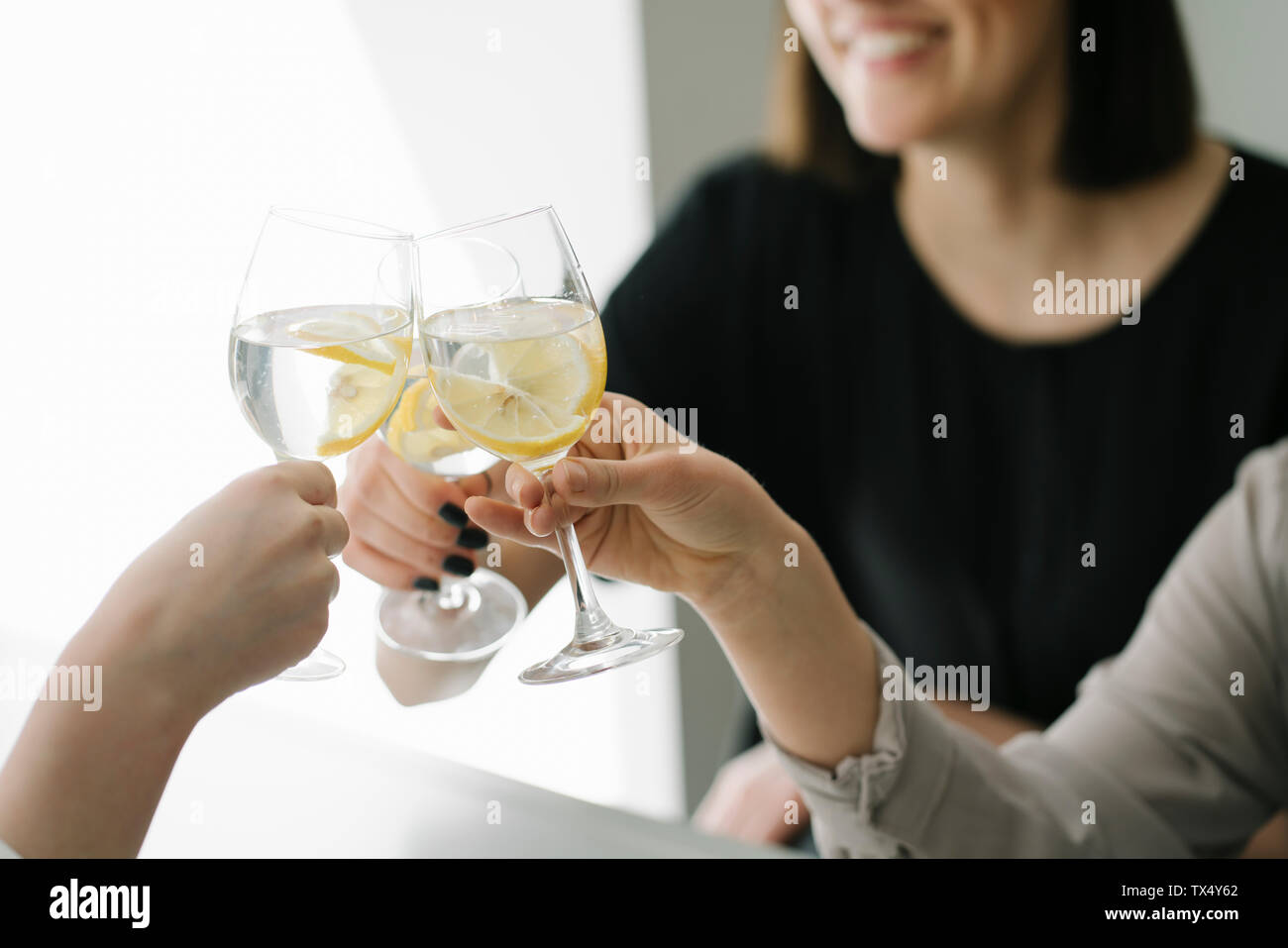 Close-up di tre donne la tostatura bicchieri di acqua Foto Stock
