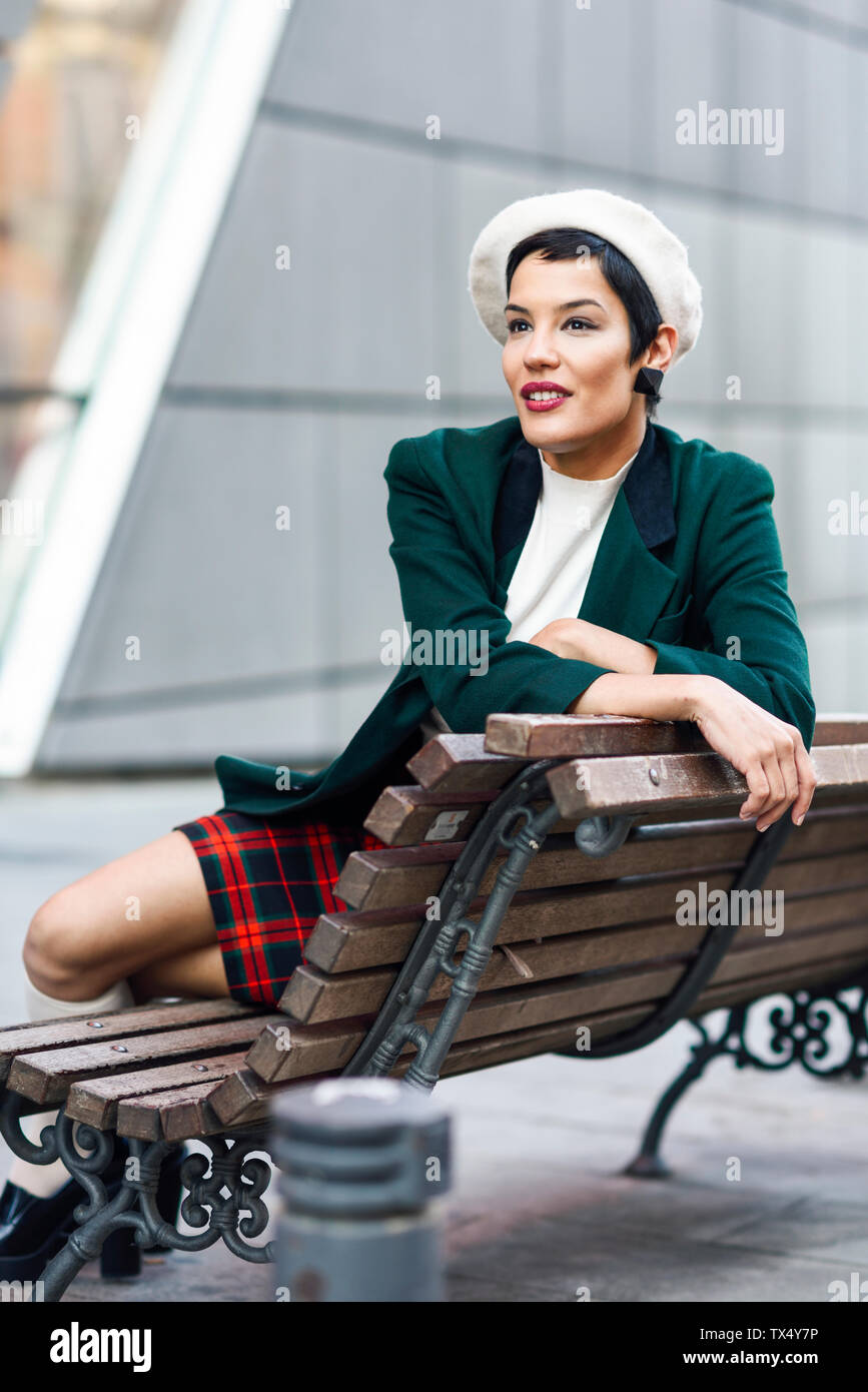 Moda giovane donna seduta su una panchina Foto Stock