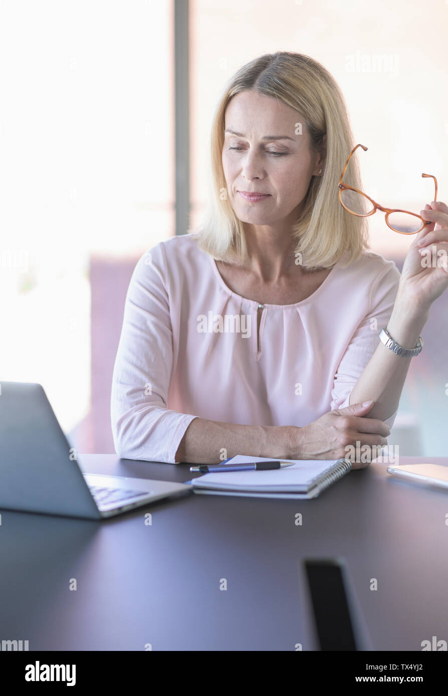 Imprenditrice utilizzando computer portatile in ufficio Foto Stock