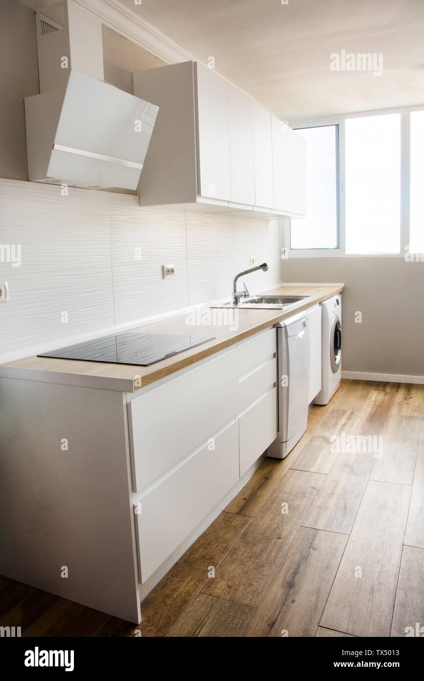 Bianco cucina moderna con arredamento bianco e pavimento in legno Foto Stock