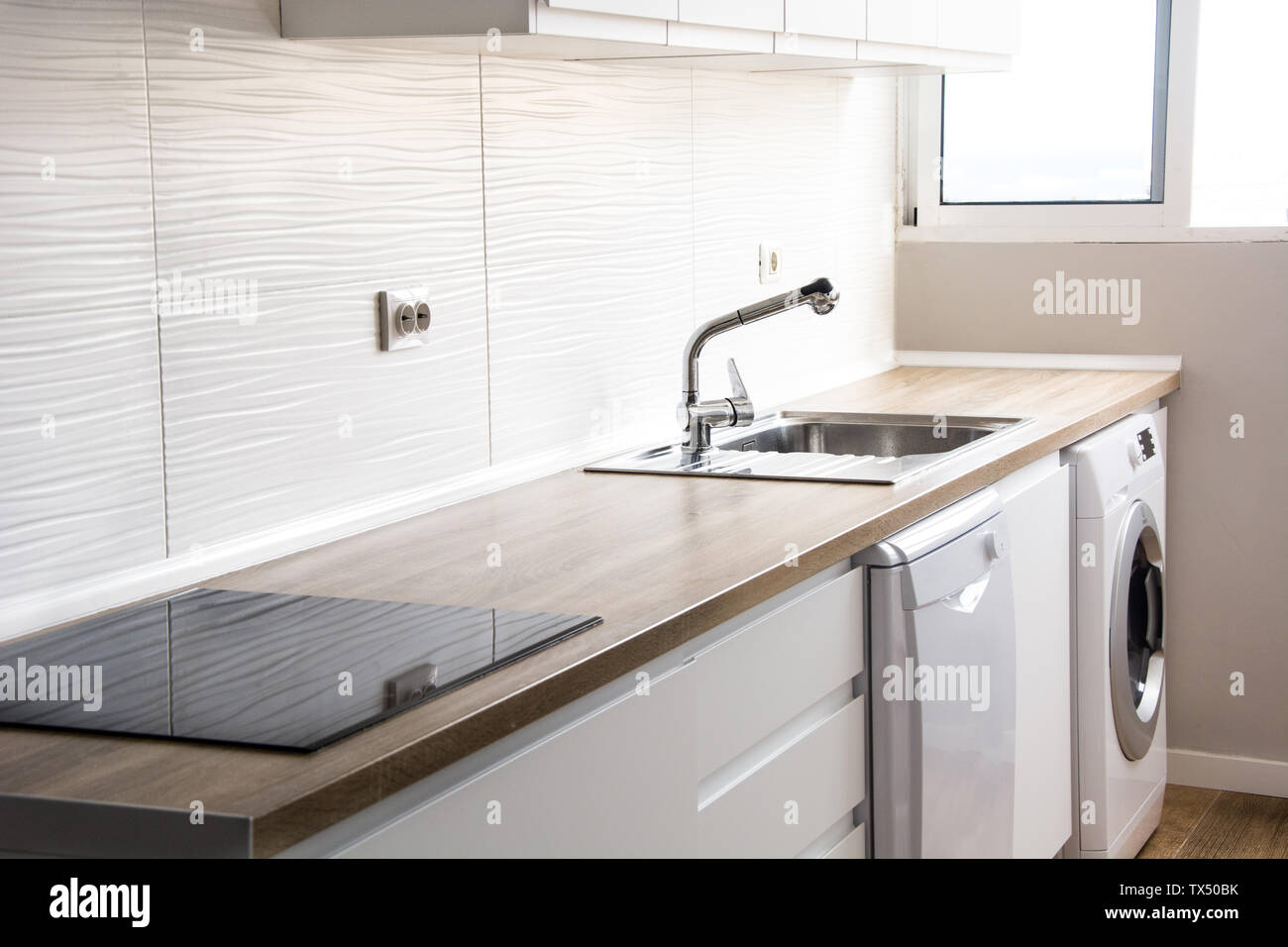 Bianco cucina moderna con arredamento bianco e pavimento in legno Foto Stock