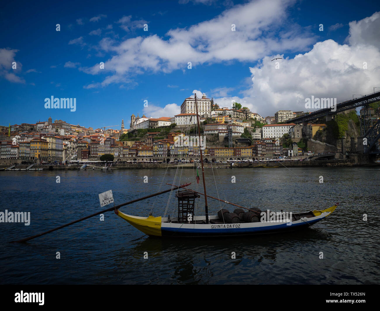 Botti di invecchiamento porta in barche sul fiume Douro a Porto in Portogallo con il Patrimonio Mondiale skyline dietro di loro Foto Stock