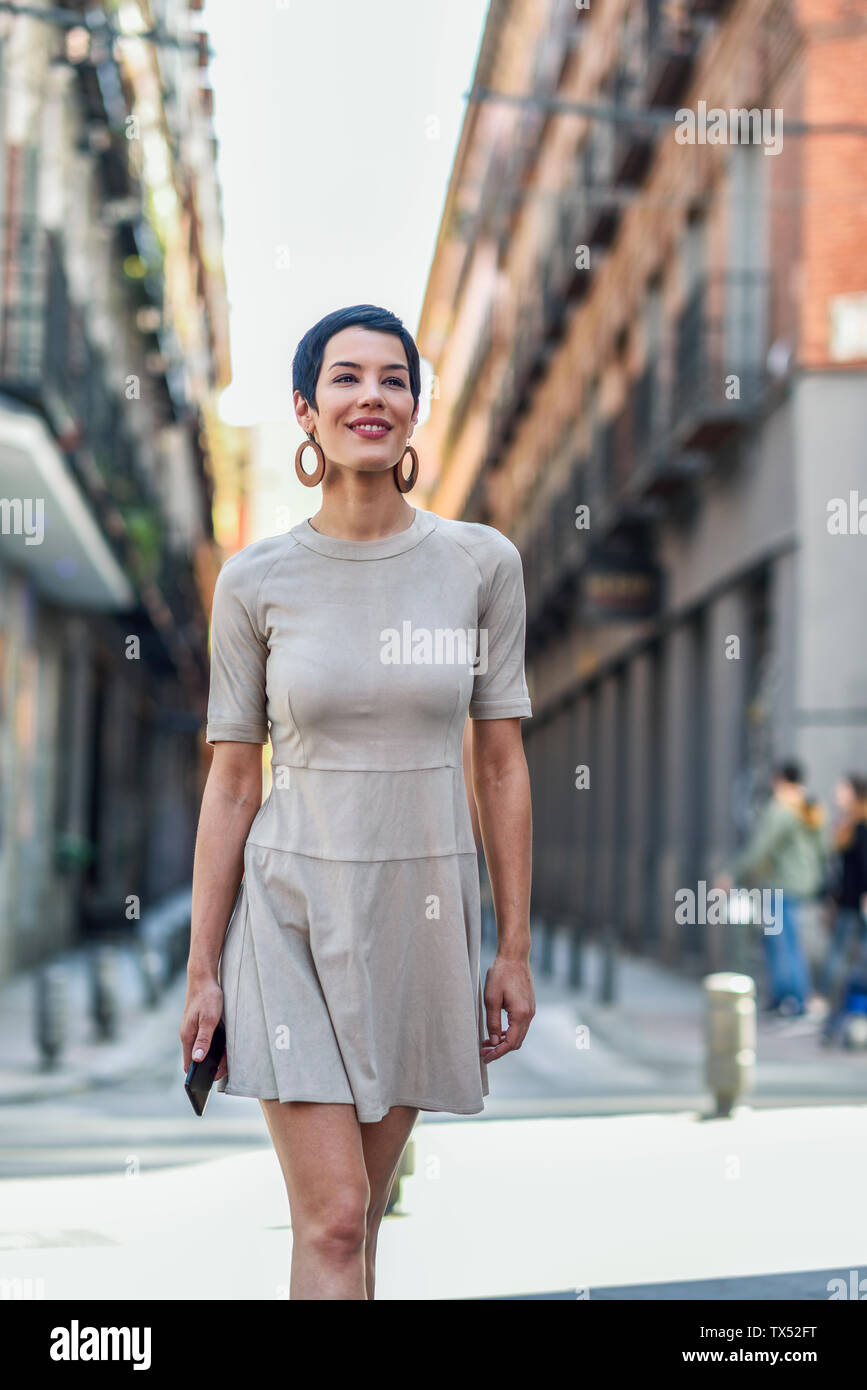 Moda giovane donna che indossa un abito a camminare in città Foto Stock
