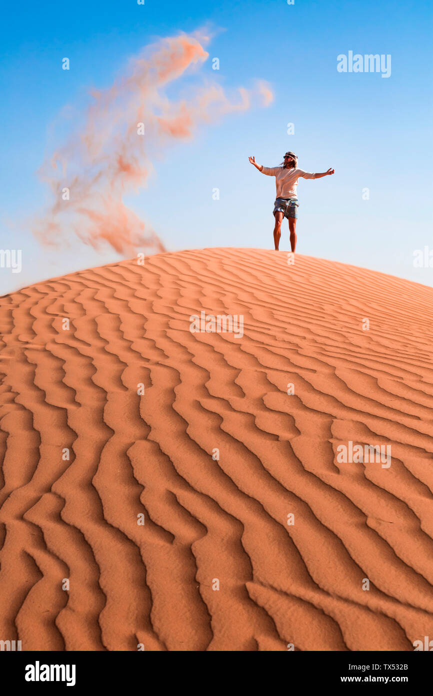 Il sultanato di Oman, Wahiba Sands, metà uomo adulto è il gioco con la sabbia nel deserto Foto Stock