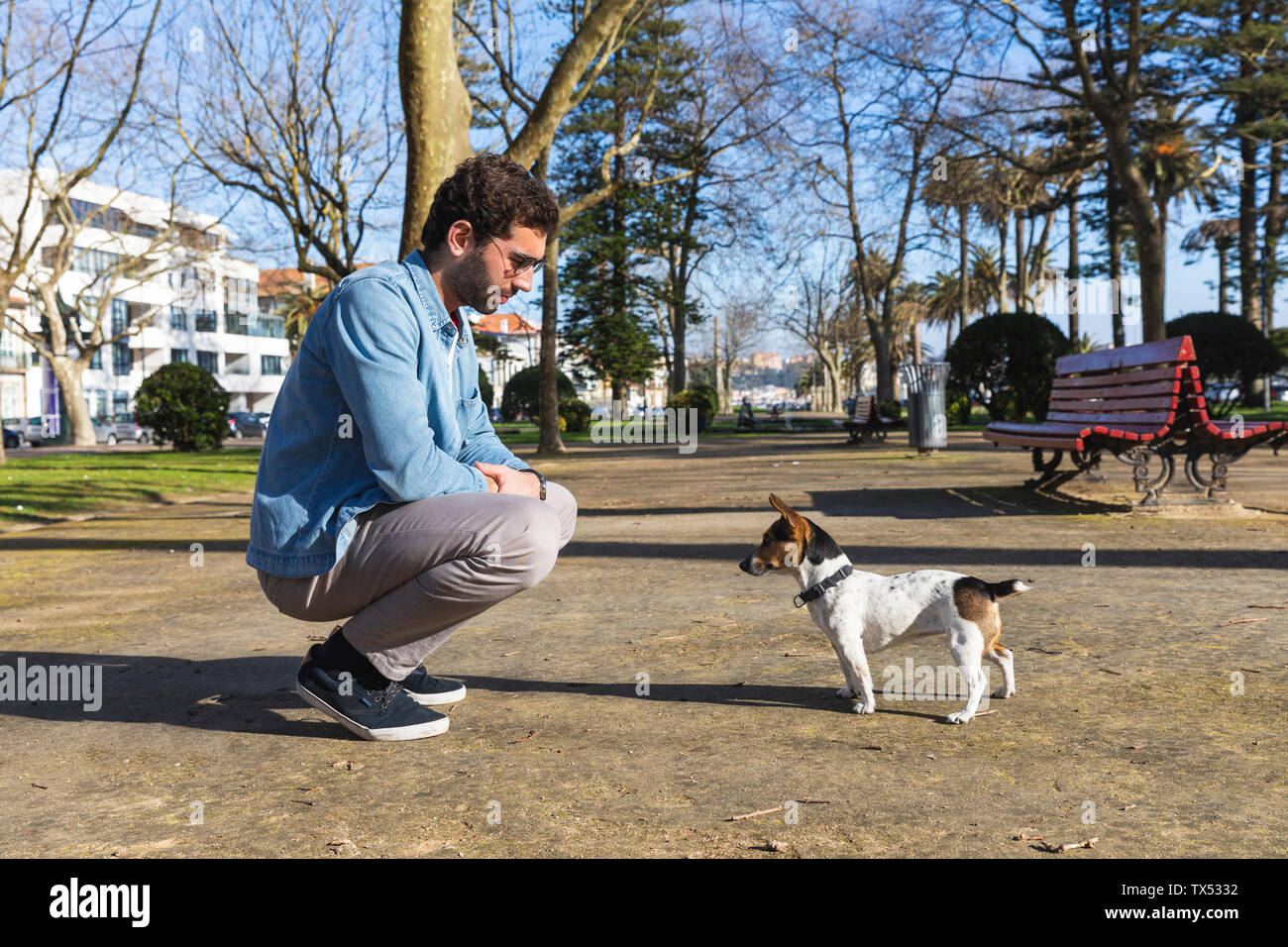 Giovane uomo l insegnamento del suo cane in un parco Foto Stock