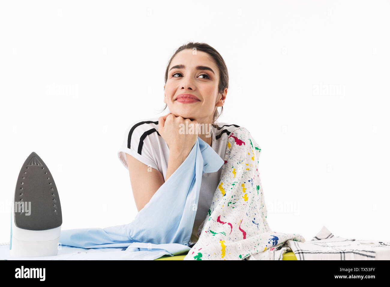 Foto di bella donna casalinga 20s vestito in abbigliamento casual a stirare  i vestiti puliti a bordo isolate su sfondo bianco Foto stock - Alamy